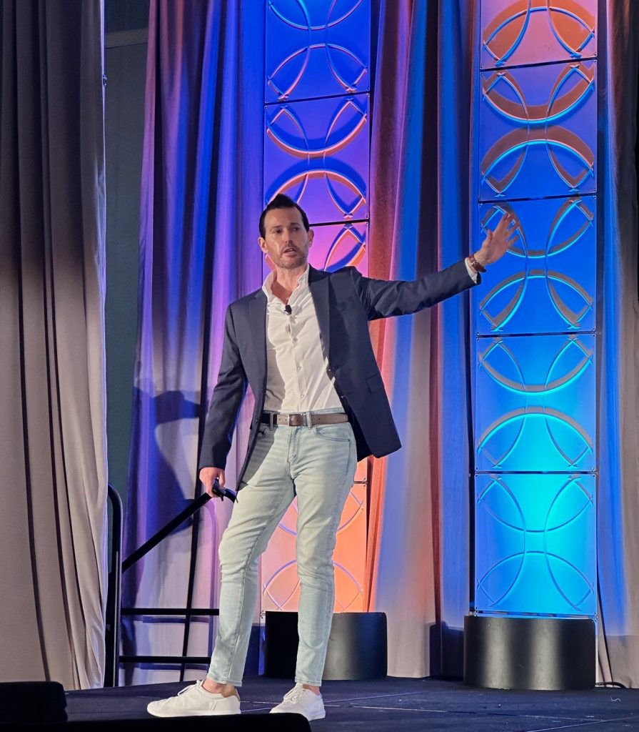 Brian Wright speaking on stage at an event